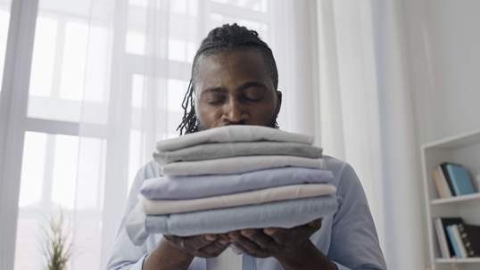 man smelling fresh laundry
