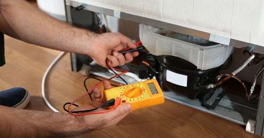 technician repairing refrigerator