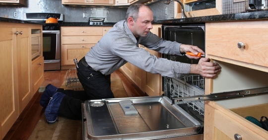 man installing dishwasher